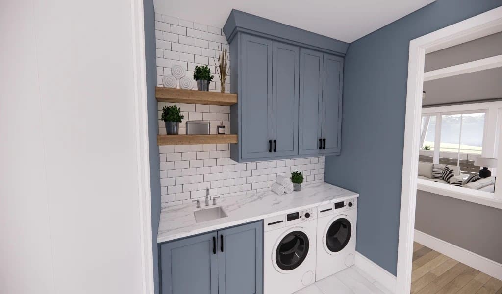 Laundry room with grayish blue cabinets, a marble countertop, and floating shelves fixed against the subway tiled backsplash.