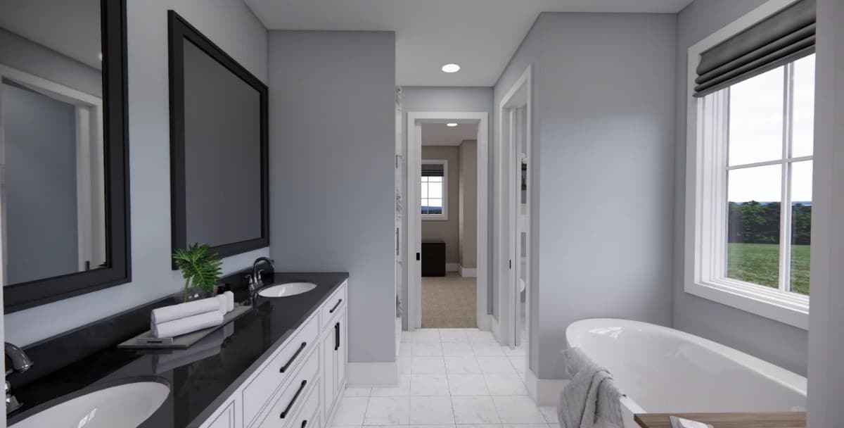 Primary bathroom with a dual sink vanity and a freestanding tub brightened by picture window.