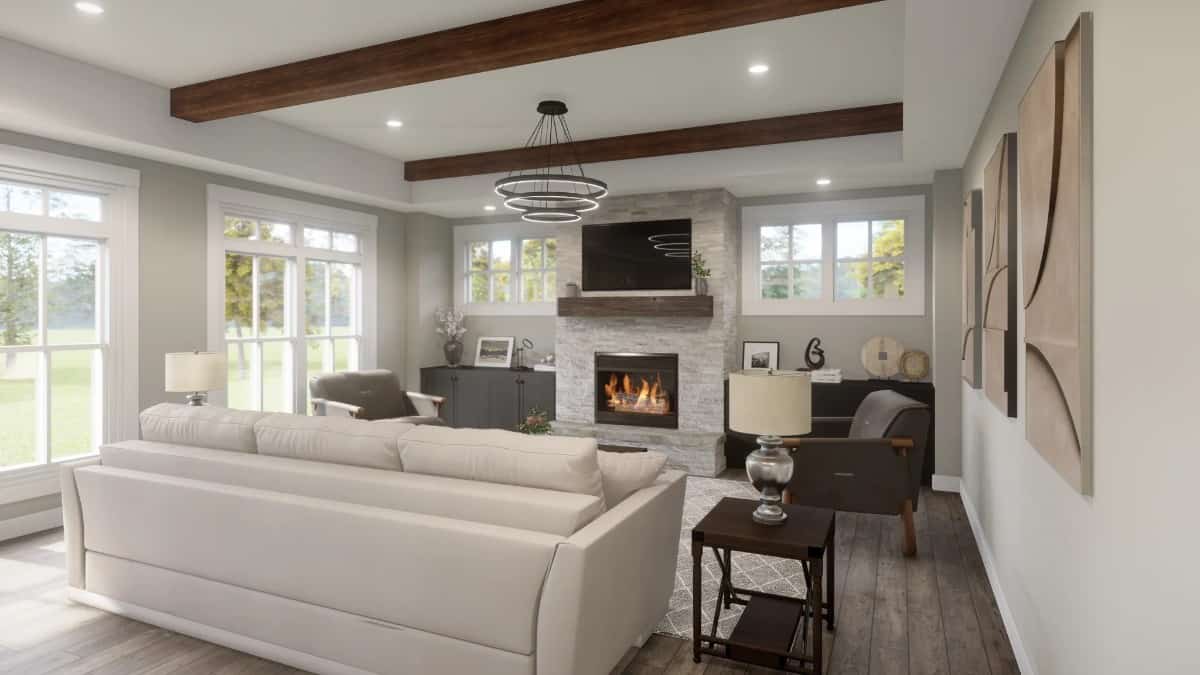 The great room has a beamed ceiling, leather seats, and a stone fireplace topped with a TV.