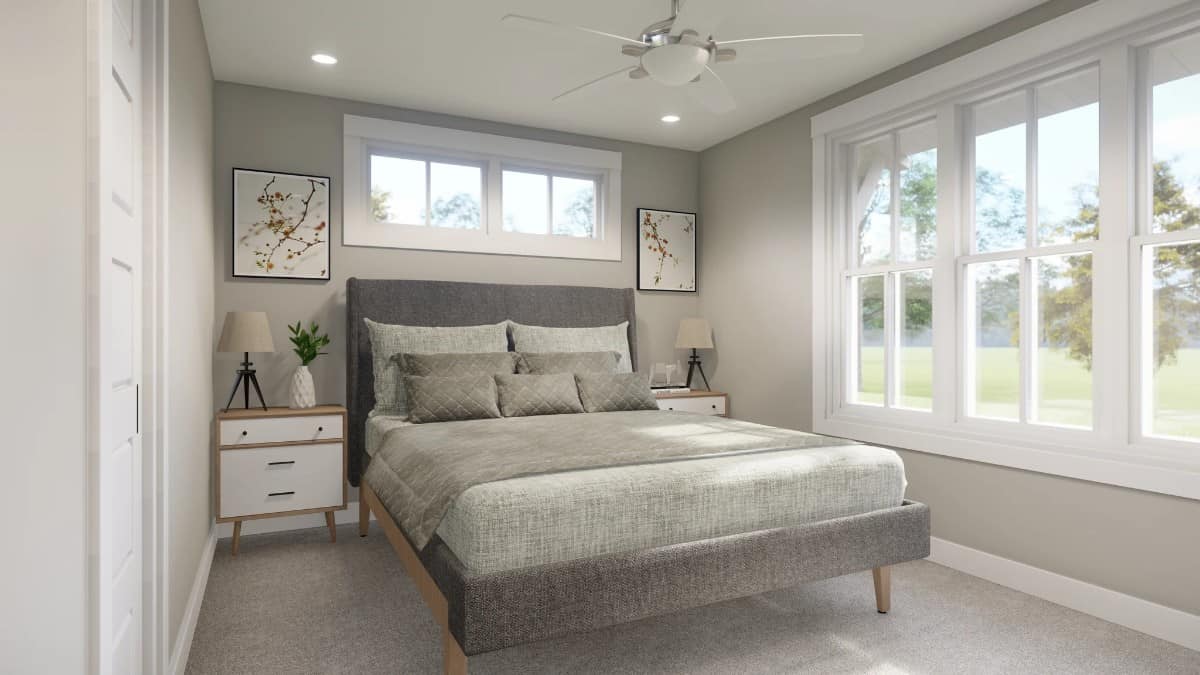 The second bedroom has lots of white-framed windows and a gray platform bed that blends in with the carpeted floor.