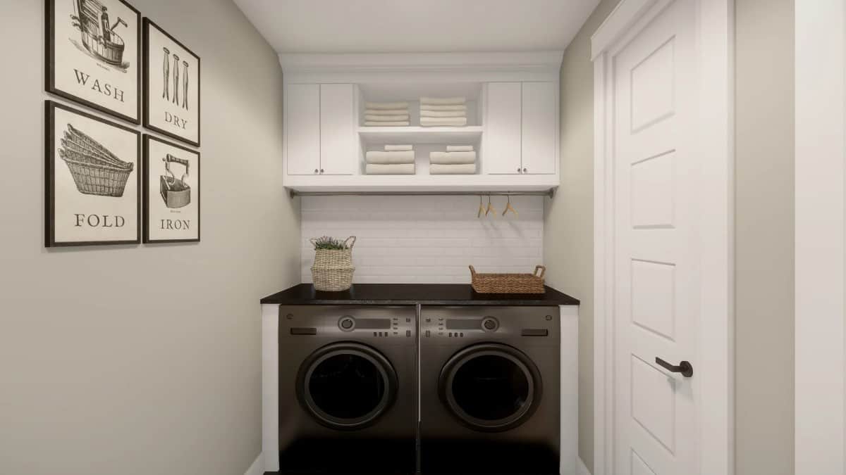 The laundry room is equipped with overhead cabinets, a black countertop, and front-load appliances.