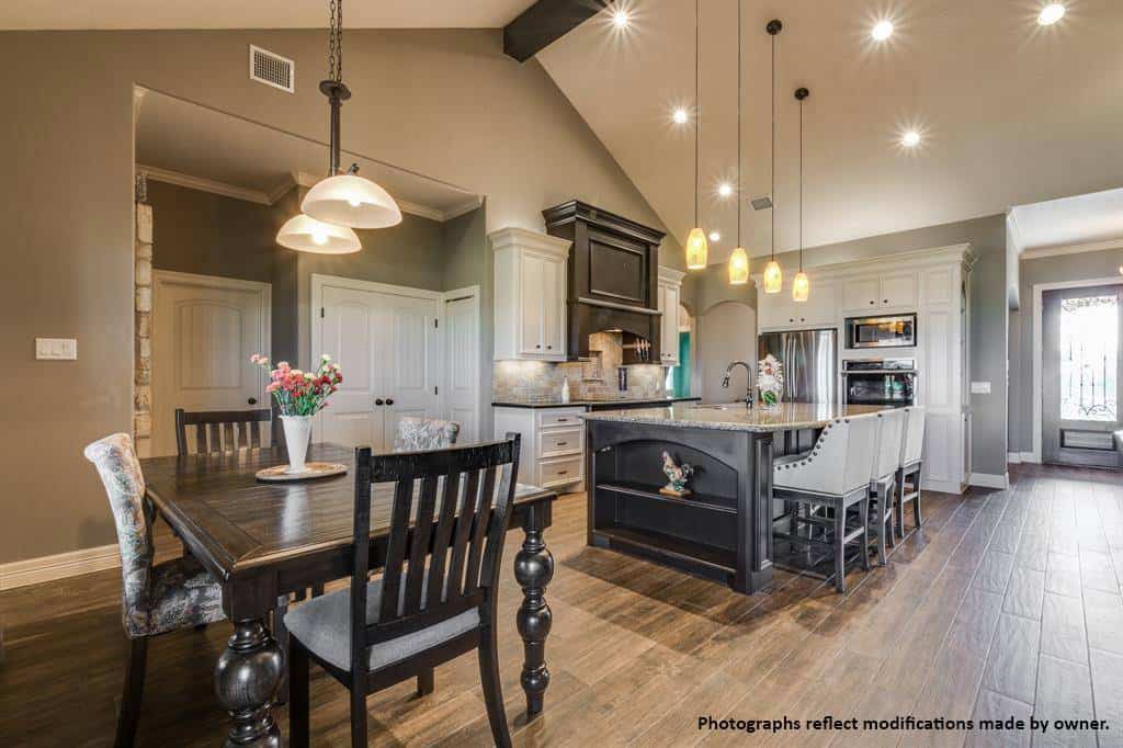 Breakfast area with dark wood chairs and a matching table topped with dome pendants.