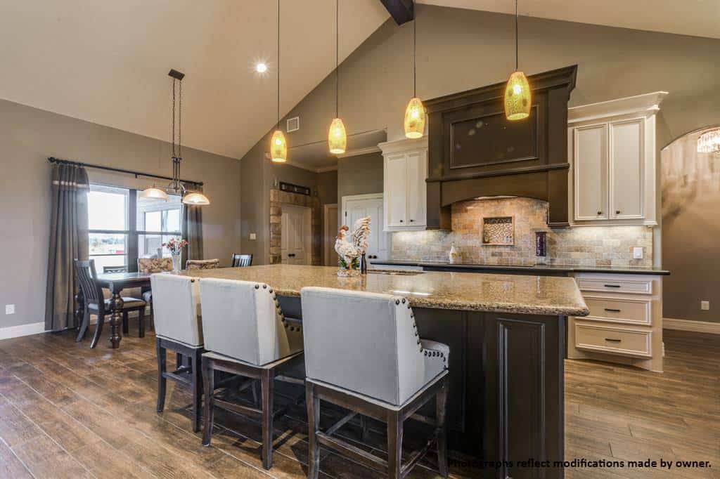 The kitchen features white cabinetry and a contrasting island paired with counter bar stools.
