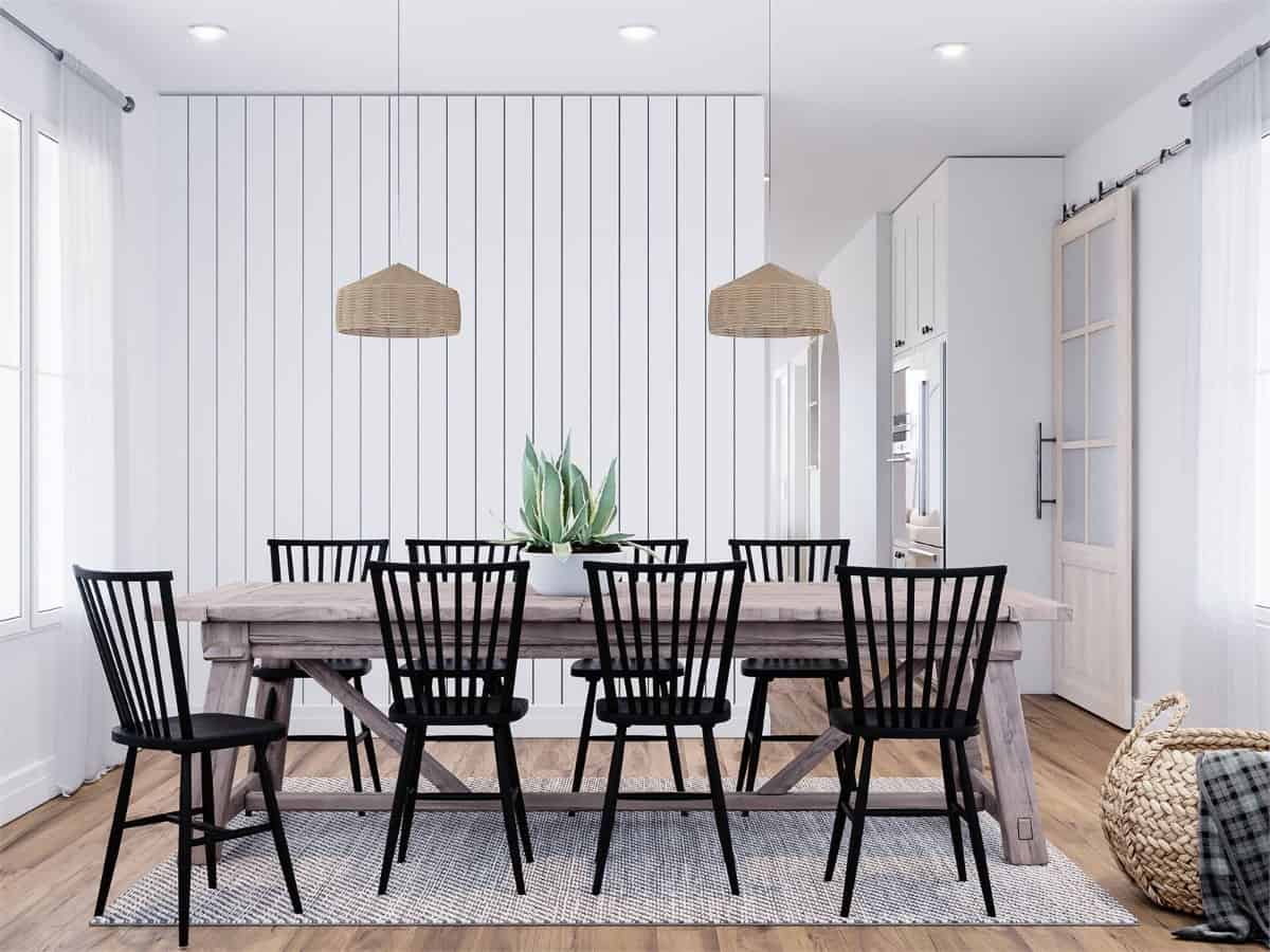 Formal dining room with black high-back chairs and a rustic wooden table topped with a couple of wicker pendants.