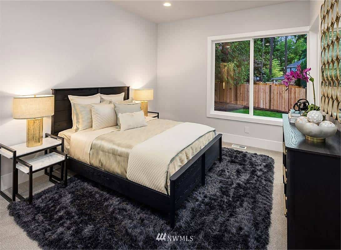 Guest bedroom with dark wood furnishings and a carpeted floor topped with a shaggy area rug.