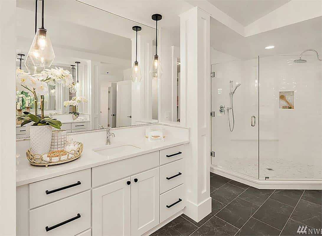 Primary vanity and walk-in shower over slate tiled flooring.