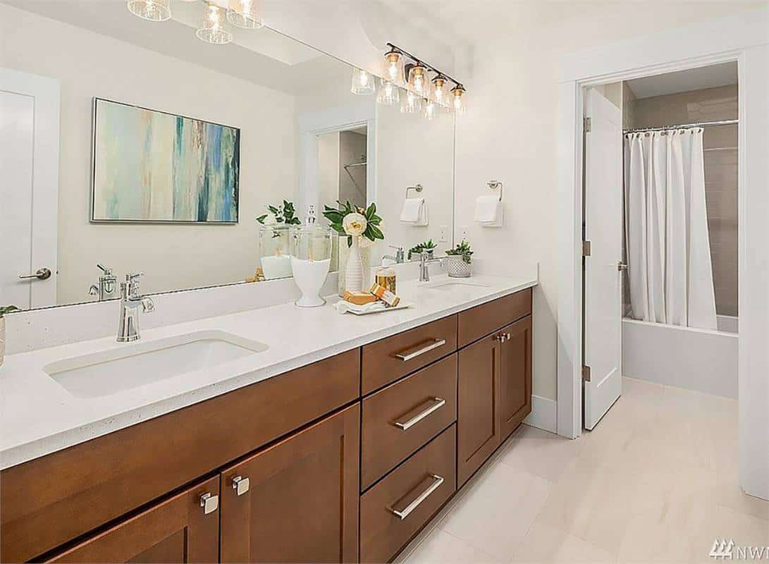 Shared bathroom with a dual sink vanity and a tub and shower combo.