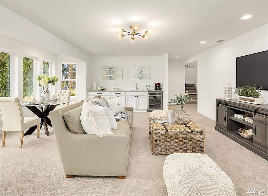 Rec room with a wall-mounted TV, a beige sofa, a round dining set, and a wet bar with a wine fridge.