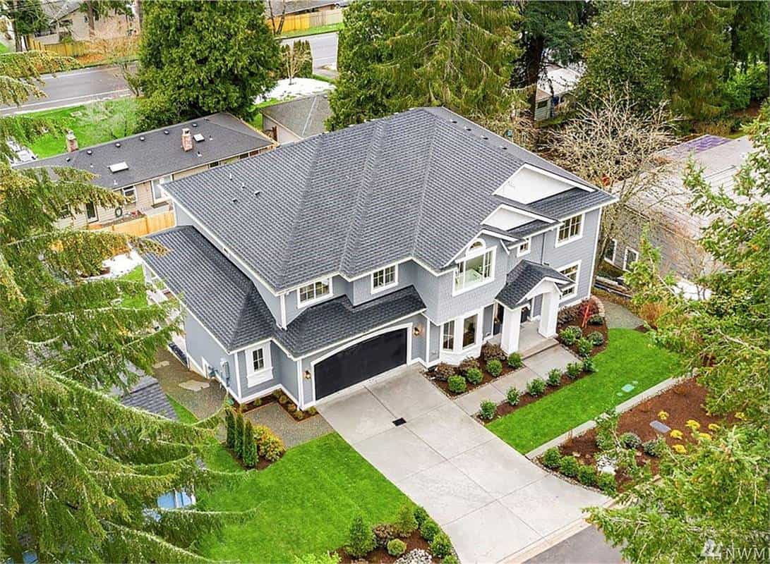 Aerial front view of the house showcasing its tiled roofs, a double front-facing garage, and a covered entry porch.