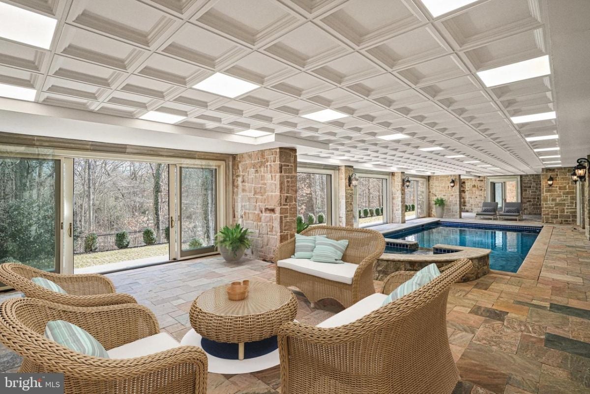 A large indoor pool with table and chairs.