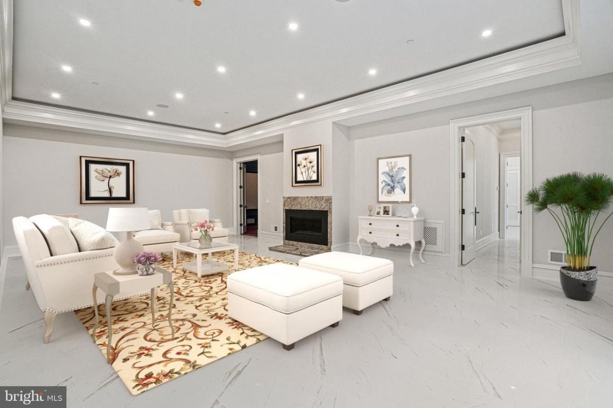 A living room with white furniture and a fireplace.