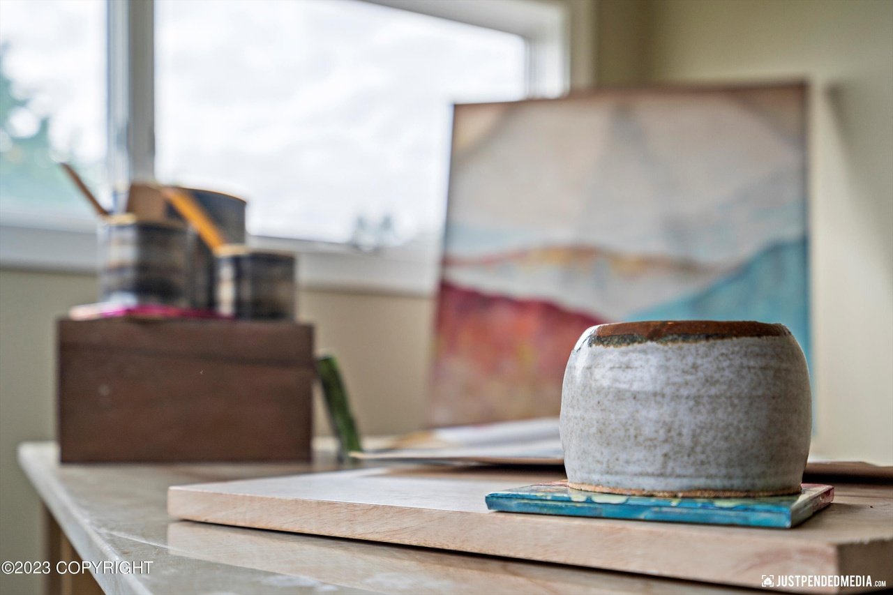 Small pot for painting sitting on top of a table.