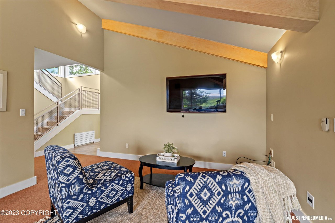 A living room with two chairs and a flat screen TV.