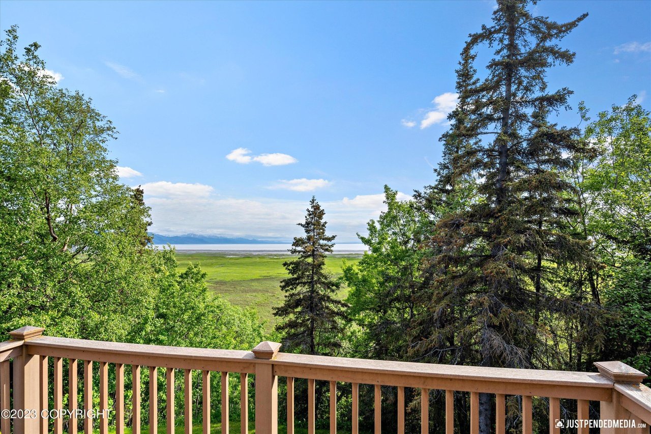 A deck with views of the ocean and the mountains.