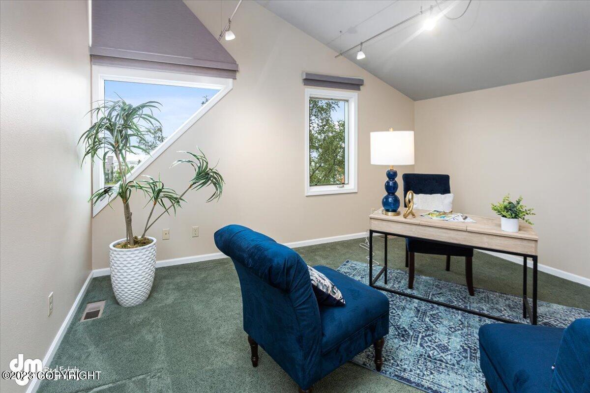 A room with a desk and blue chairs.