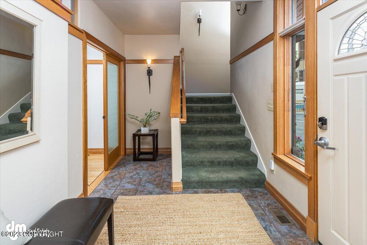 Foyer with a door, stairs and a window