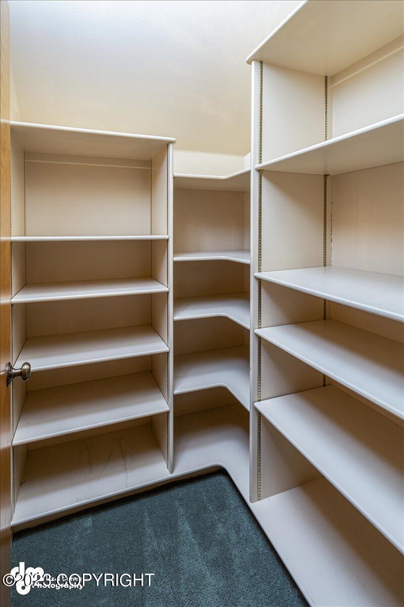 Walk in closet with shelves.