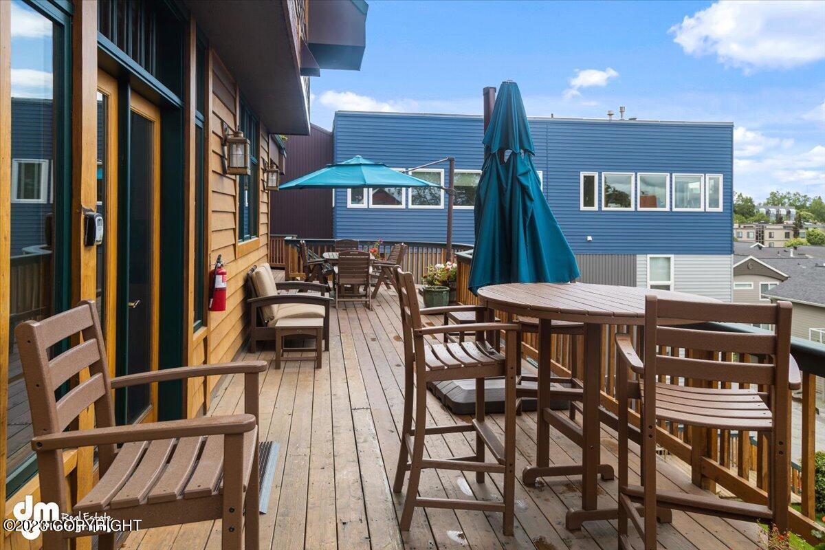 A deck with chairs and umbrella.