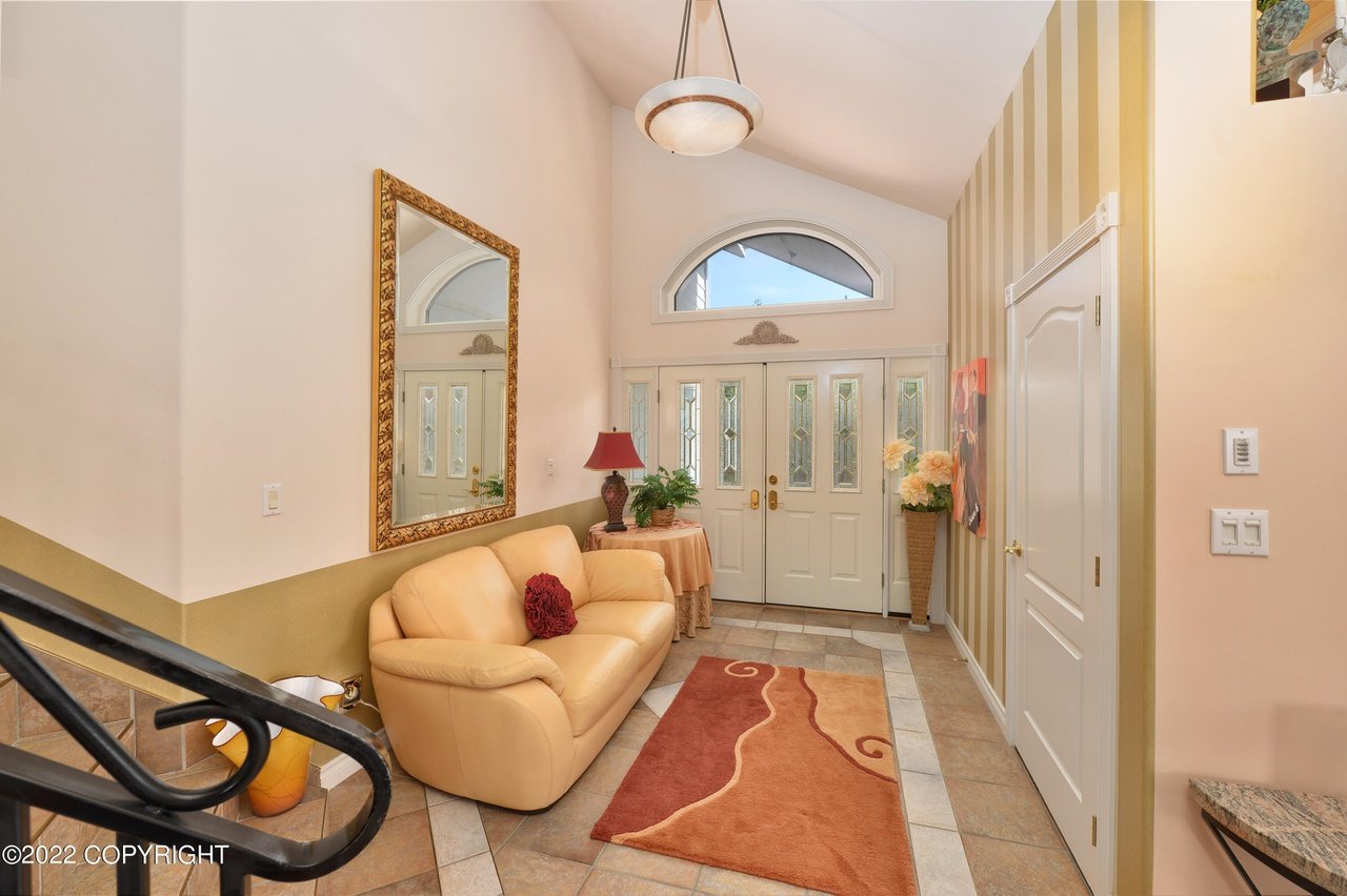 A hallway with a couch and a mirror.