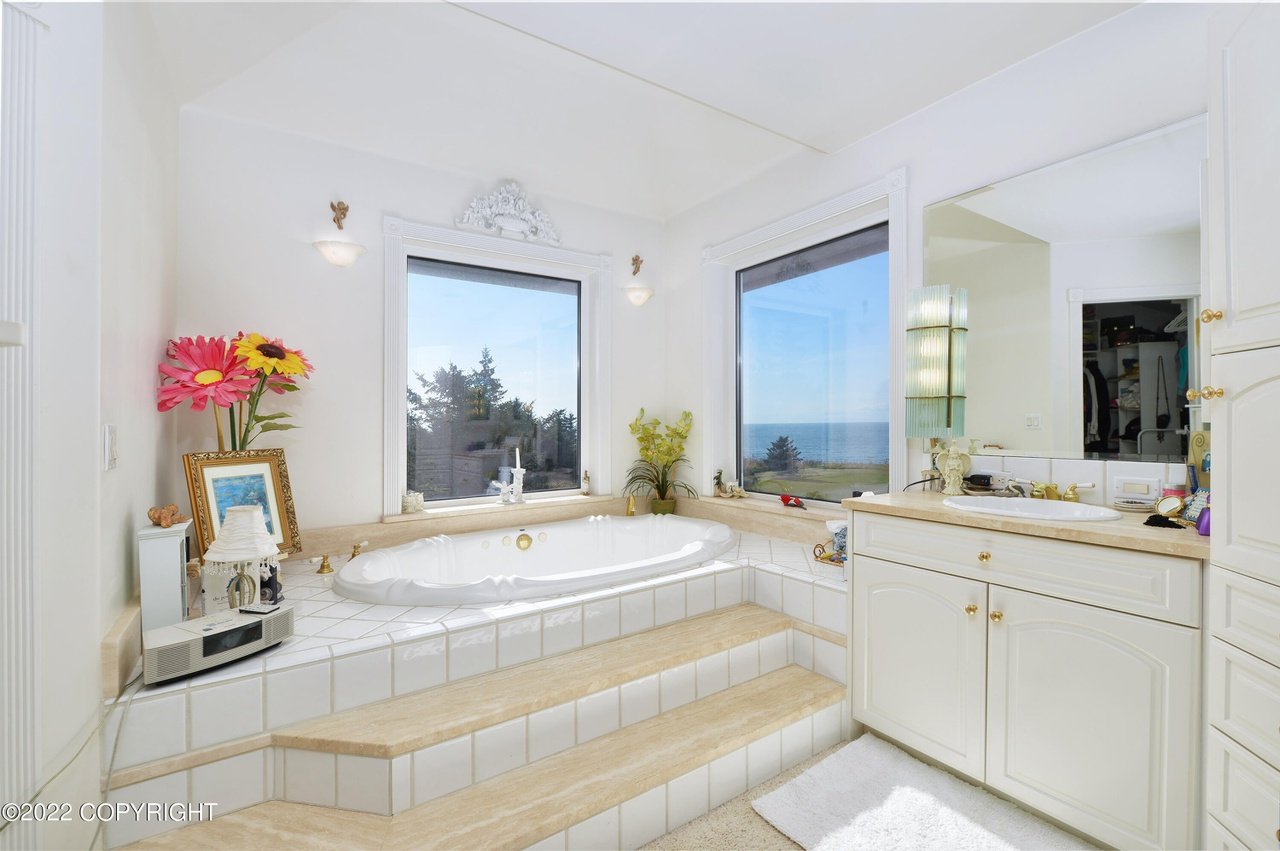 A bathroom with a large tub and a large window.
