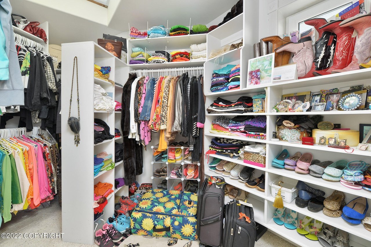 A closet with lots of clothes and bags.