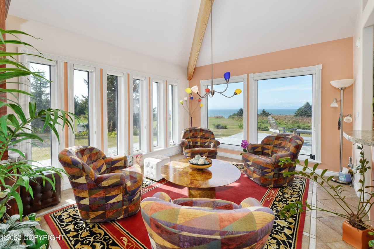 A living room with a large window and a large carpet.