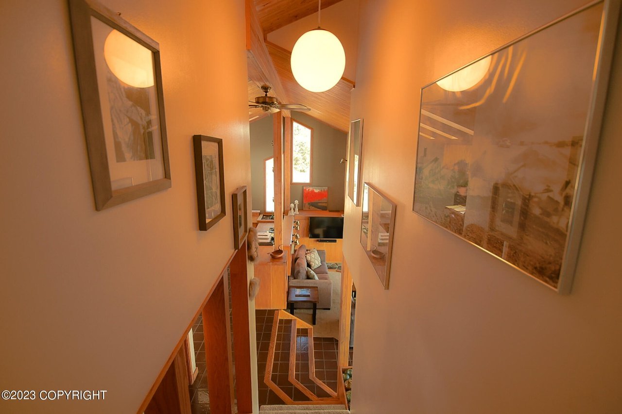 A hallway with a staircase and a picture hanging on the wall.