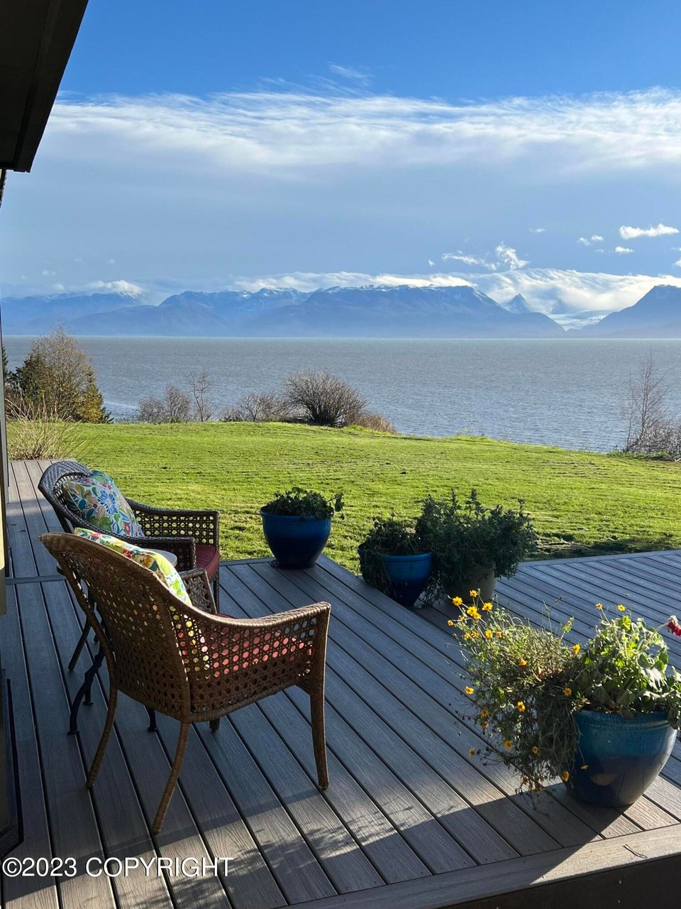 A patio with a view of the ocean and mountains.