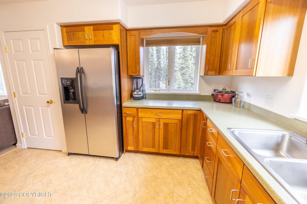 A kitchen with a refrigerator and a sink.