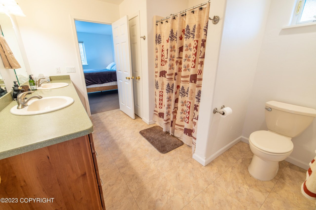 Bathroom with a toilet, sink, and shower.