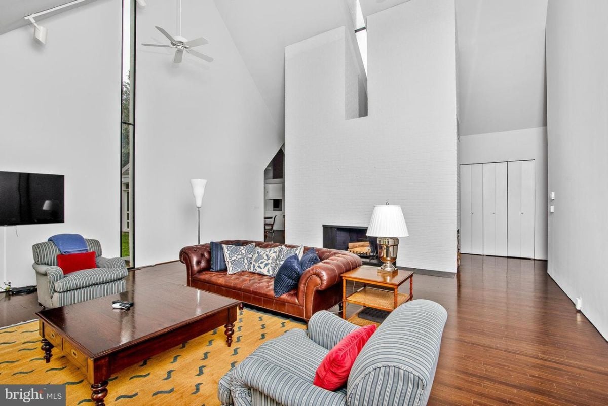 A living room with a couch, television and a fireplace.