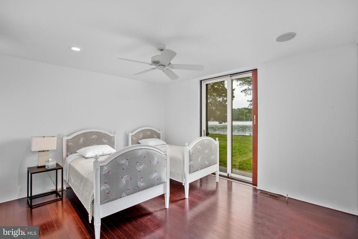A bedroom with two beds and a ceiling fan.