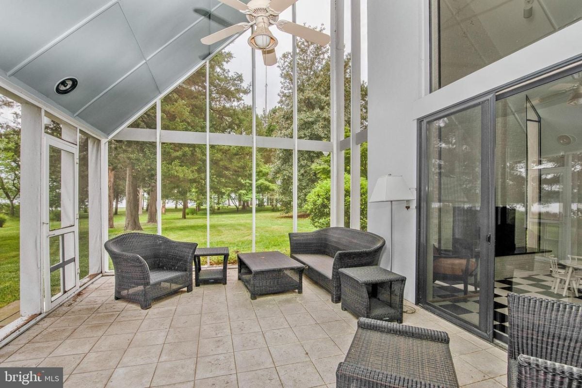 A screened patio with table and chairs.