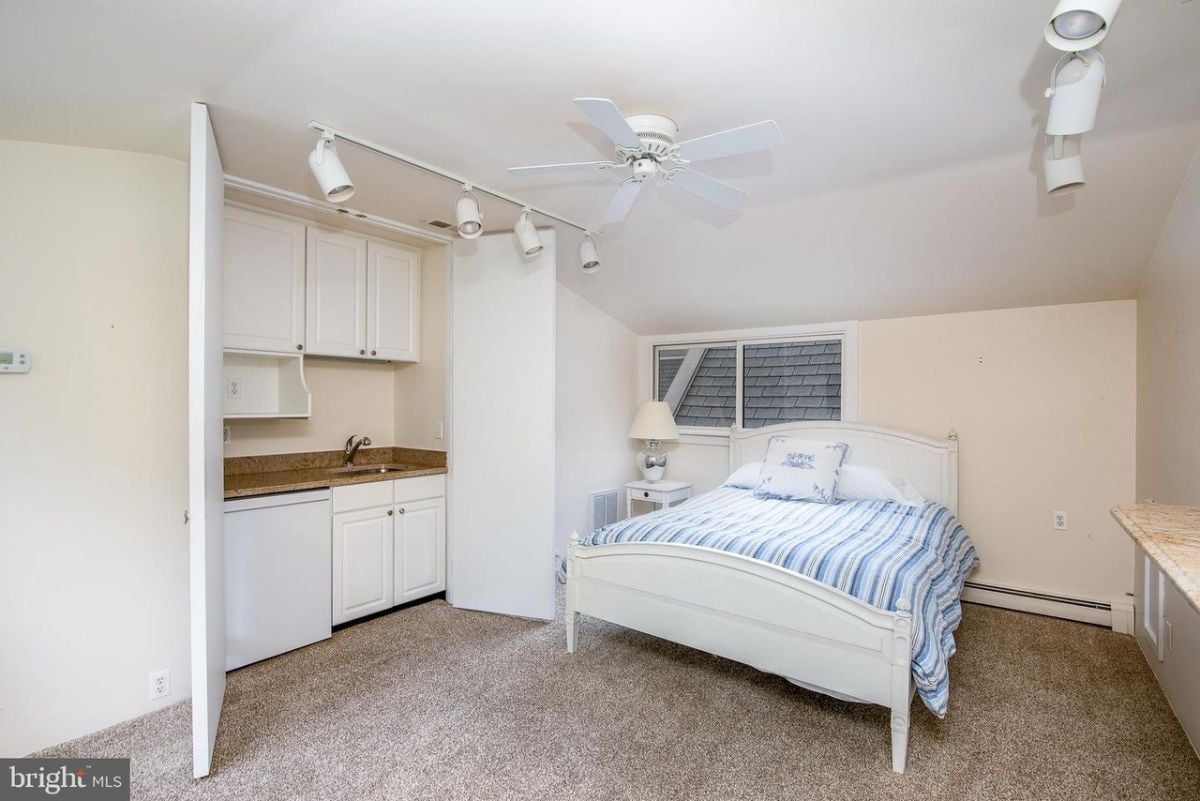 A bedroom with a bed, and sink.