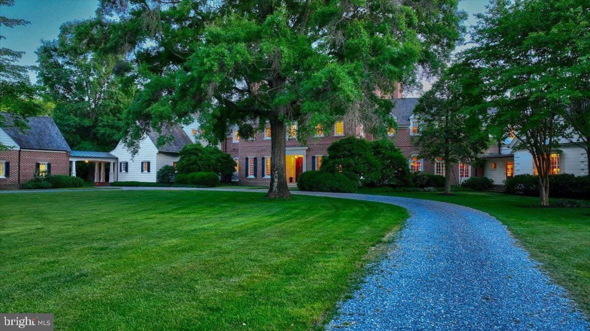 A house with a driveway and trees in the background.