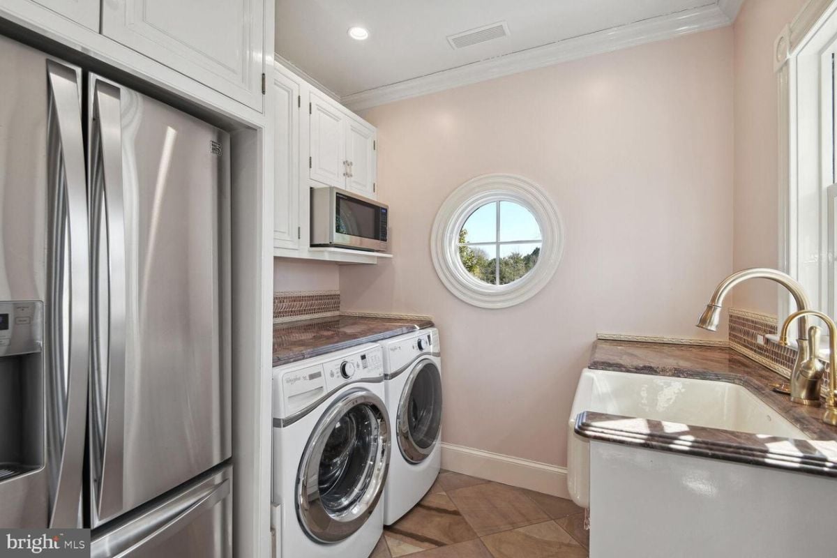 A laundry room with a washer and a sink.