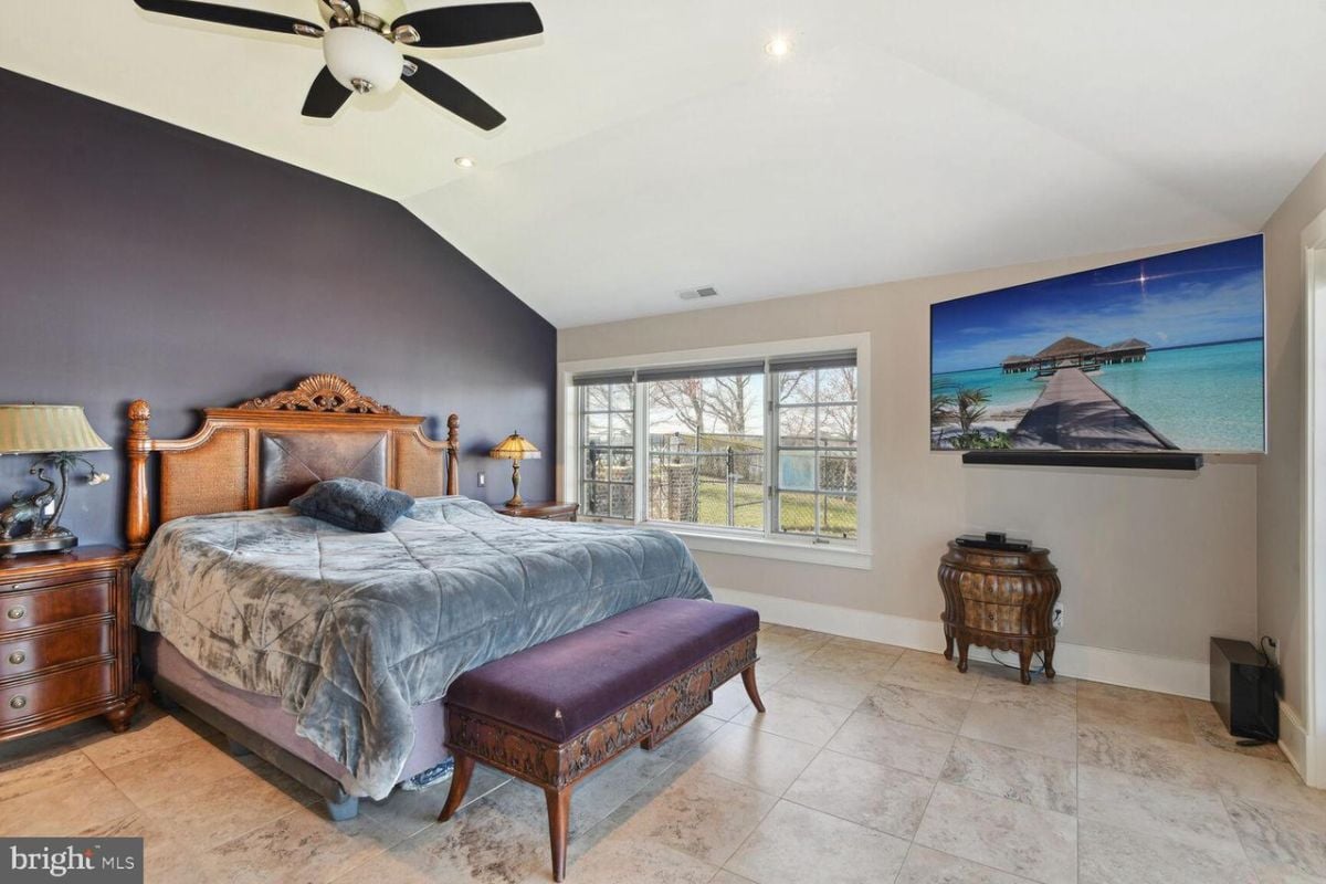 A bedroom with a large bed and a ceiling fan.