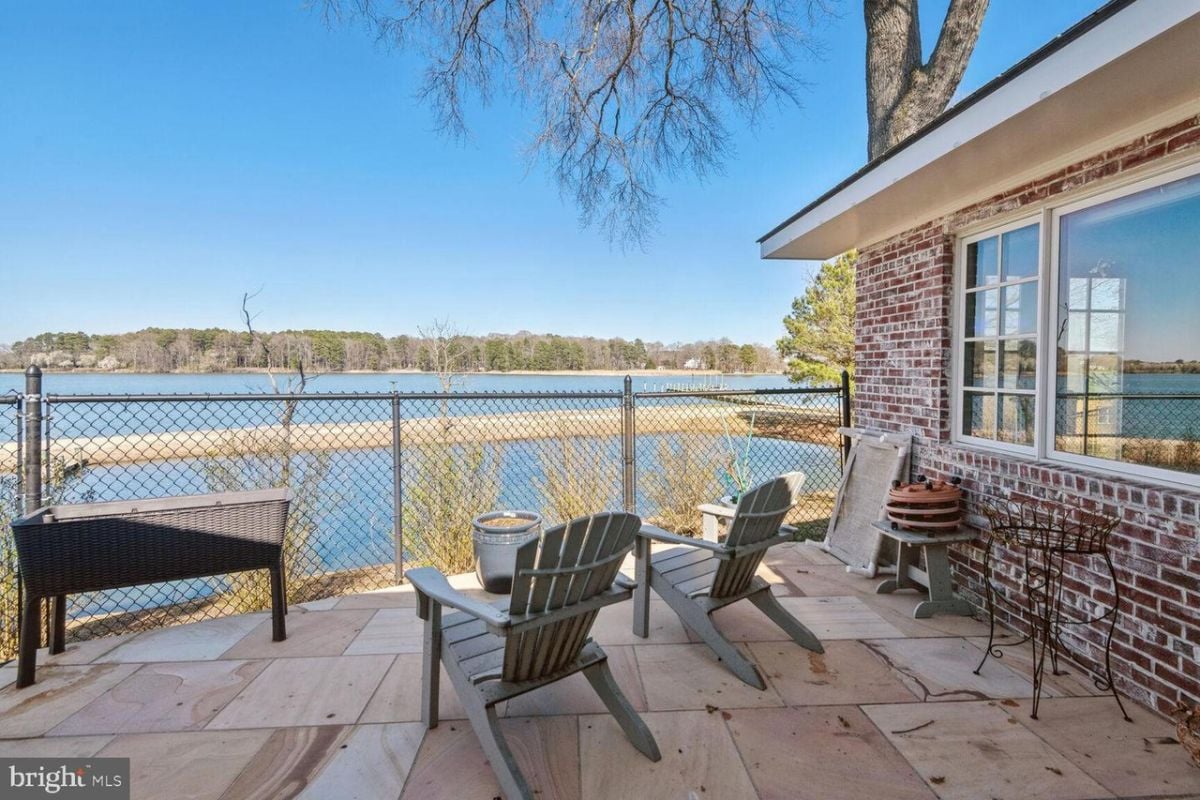 A patio with chairs and a view of the water.