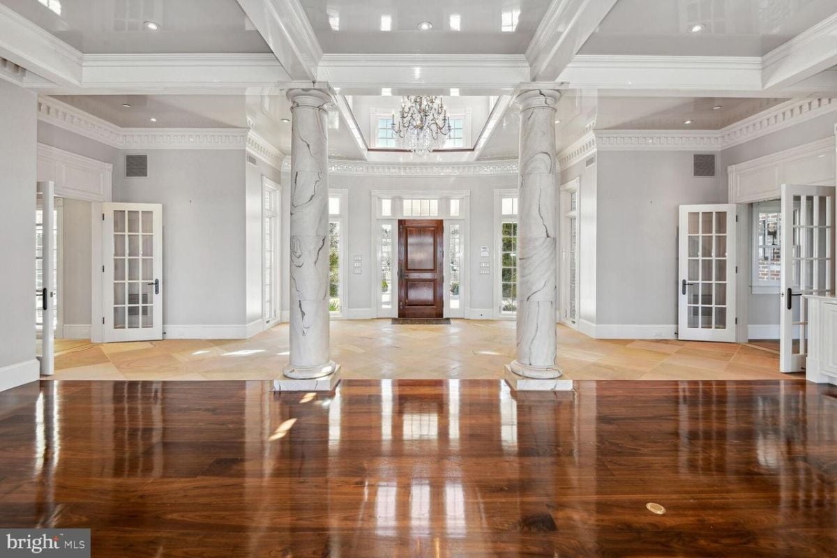 A large foyer with wood floors and white walls.