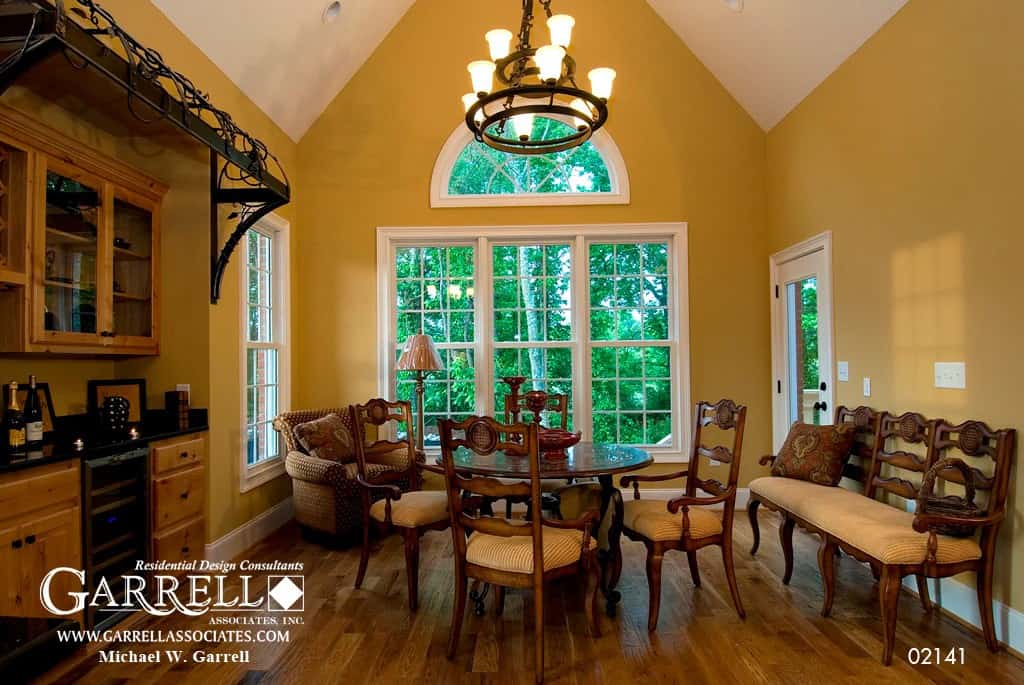 Breakfast room with a built-in bar and a round dining set under a cathedral ceiling.