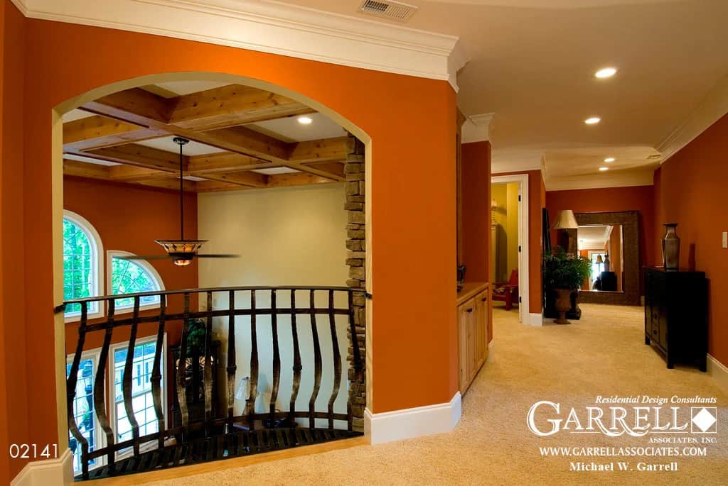 Balcony with a carpeted floor, red walls, and wrought iron railings.