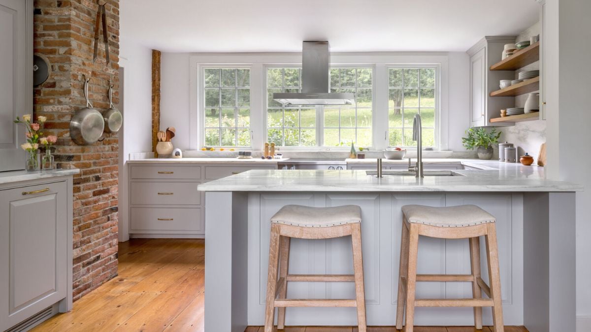 A kitchen with two stools and a brick wall
