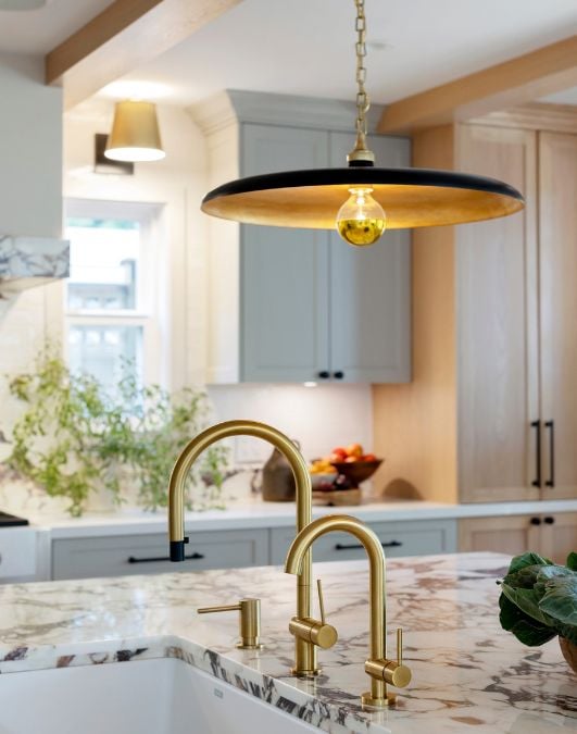 A kitchen with a sink and a hanging light