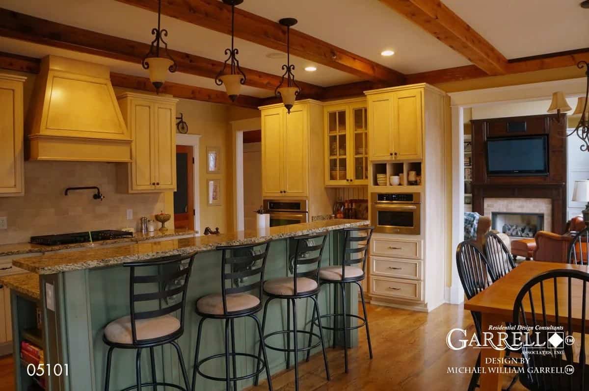 Kitchen with white cabinetry and a breakfast island with a raised eating bar.
