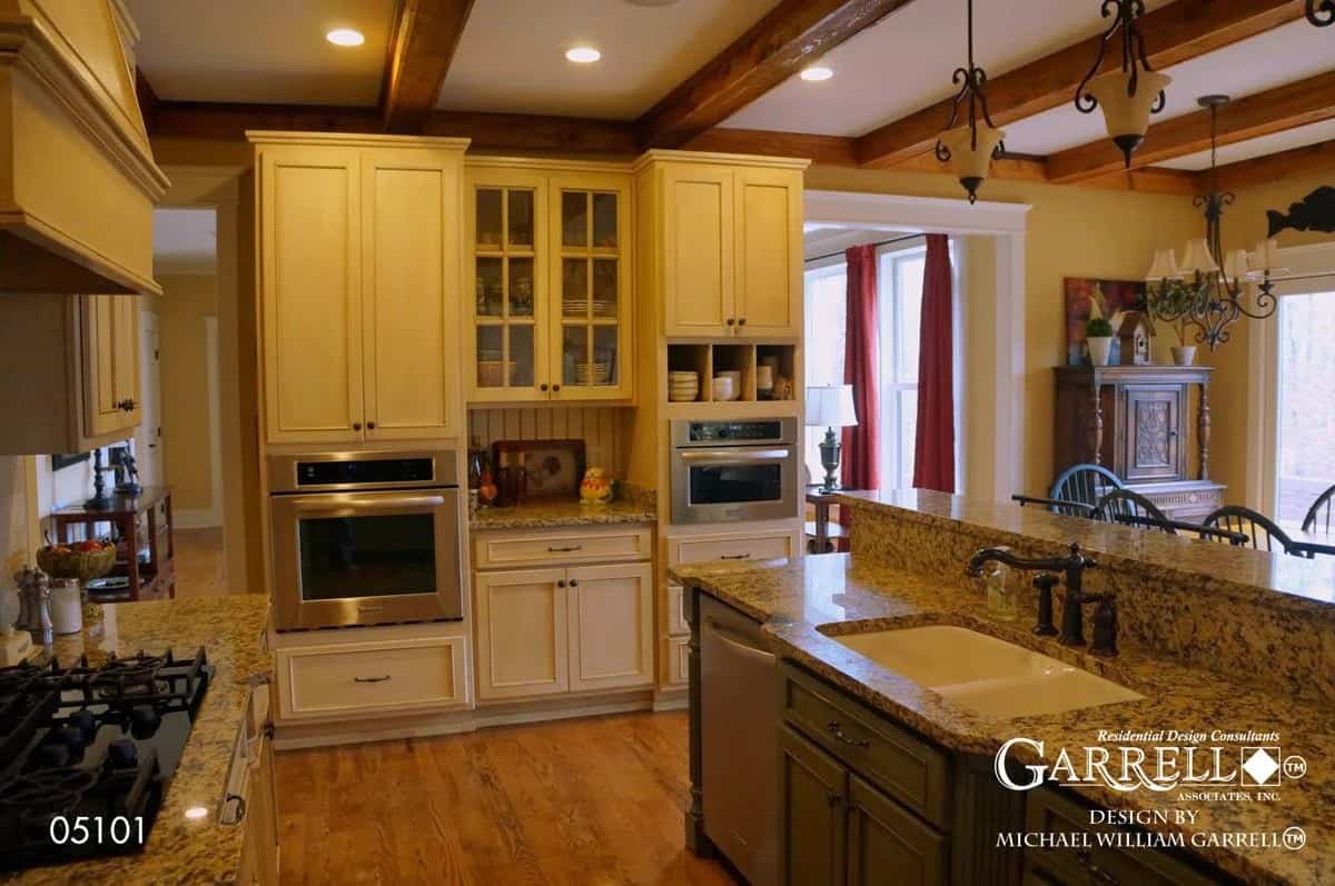 A beamed ceiling mounted with ornate iron pendants crowns the kitchen.