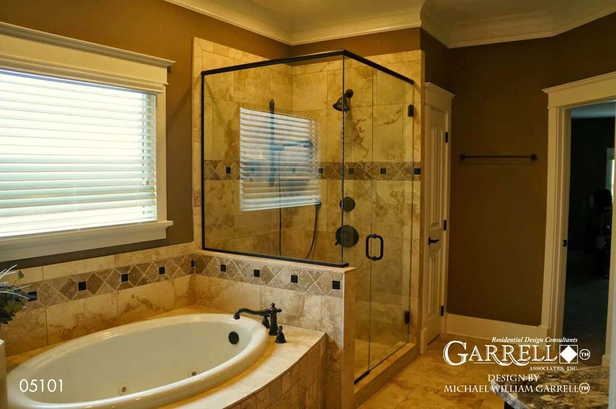 Primary bathroom with a tiled shower and a drop-in bathtub under a picture window.