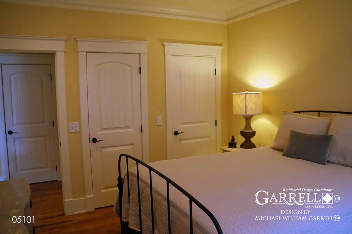 Secondary bedroom with a metal bed, a closet, and an ensuite bath.