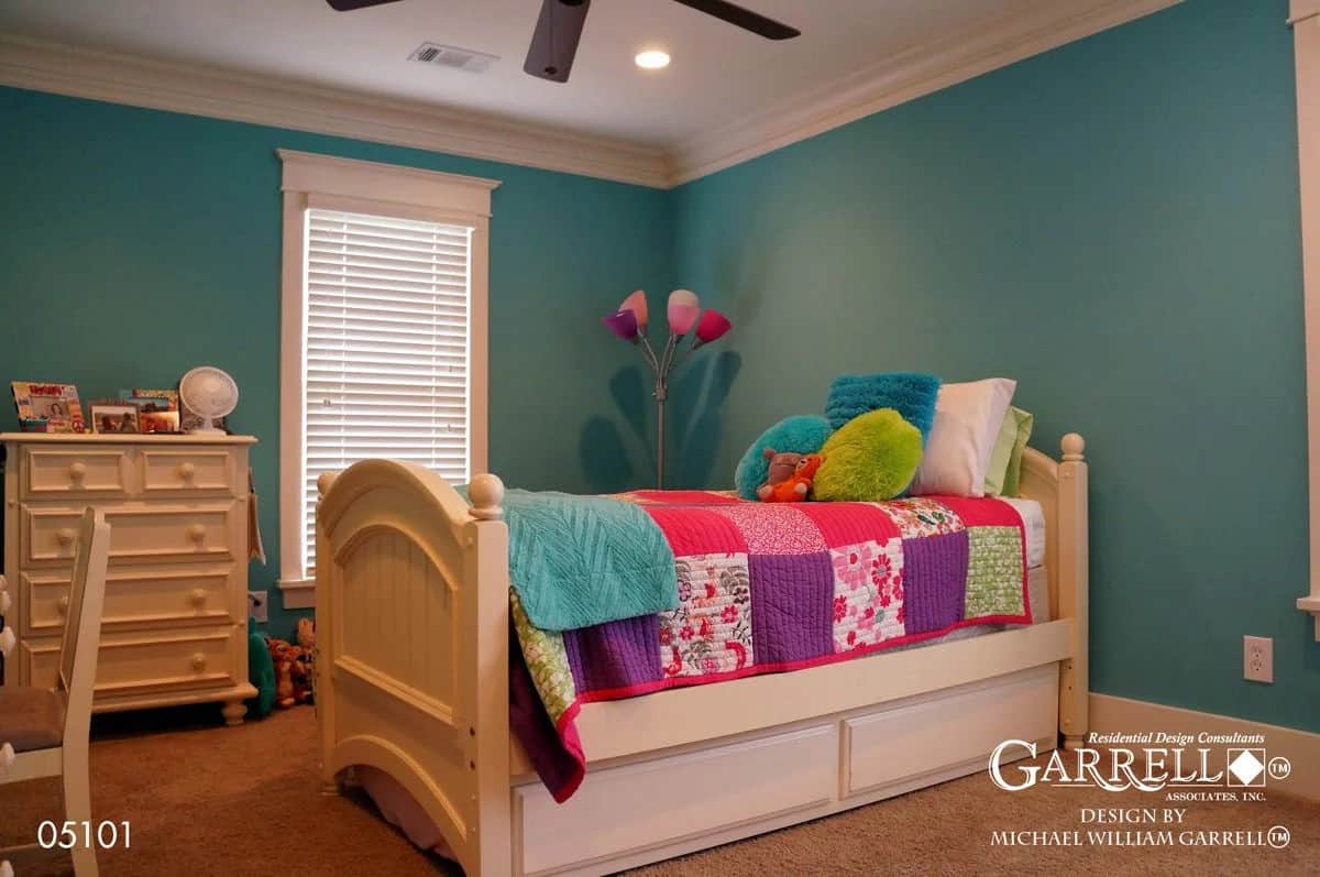 Secondary bedroom with teal walls, a tall window, and a white bed over the carpeted floor.