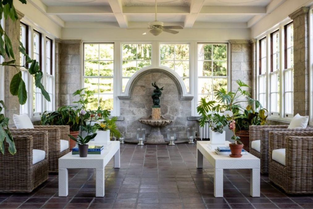 Sun room filled with lots of plants and furniture