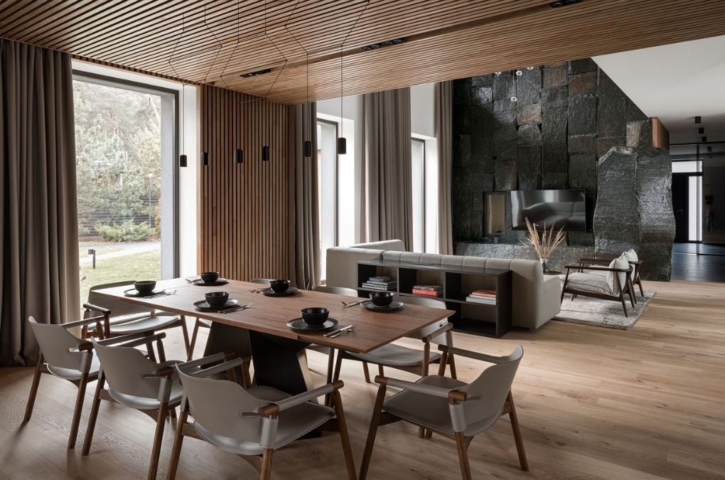 The dining room showcases a wooden table, wooden flooring, and a wooden ceiling.